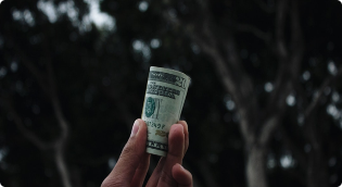 Holding money waded up to the sky