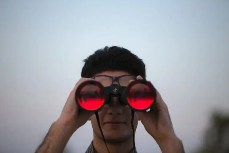 man looking through binoculars