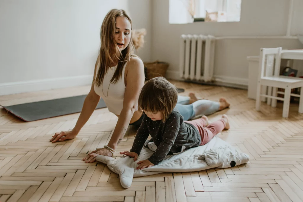 Mom and child practice yoga at home.