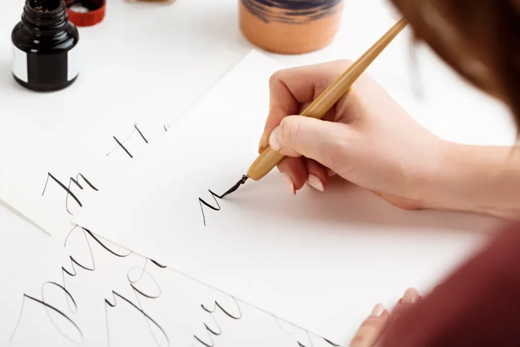 Person practicing calligraphy with ink pen