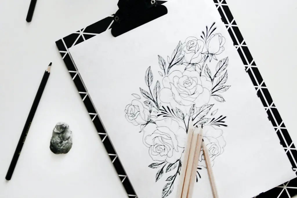 Charcoal drawn flowers on a black clip board