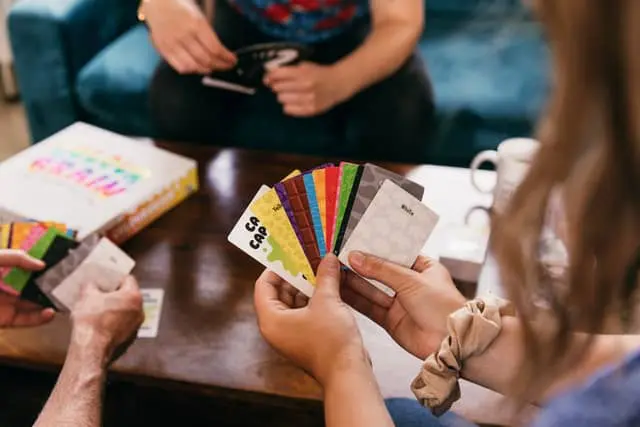 Friends around a coffee table playing cards