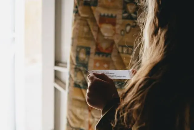 Child reading a clue on a scrap of paper in scavenger hunt