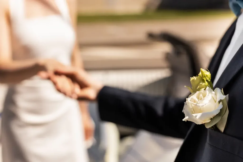 Slightly out of focus image of bride and groom holding hands