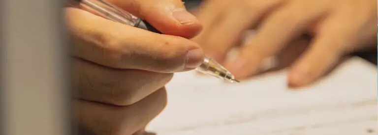 person holding pencil to write