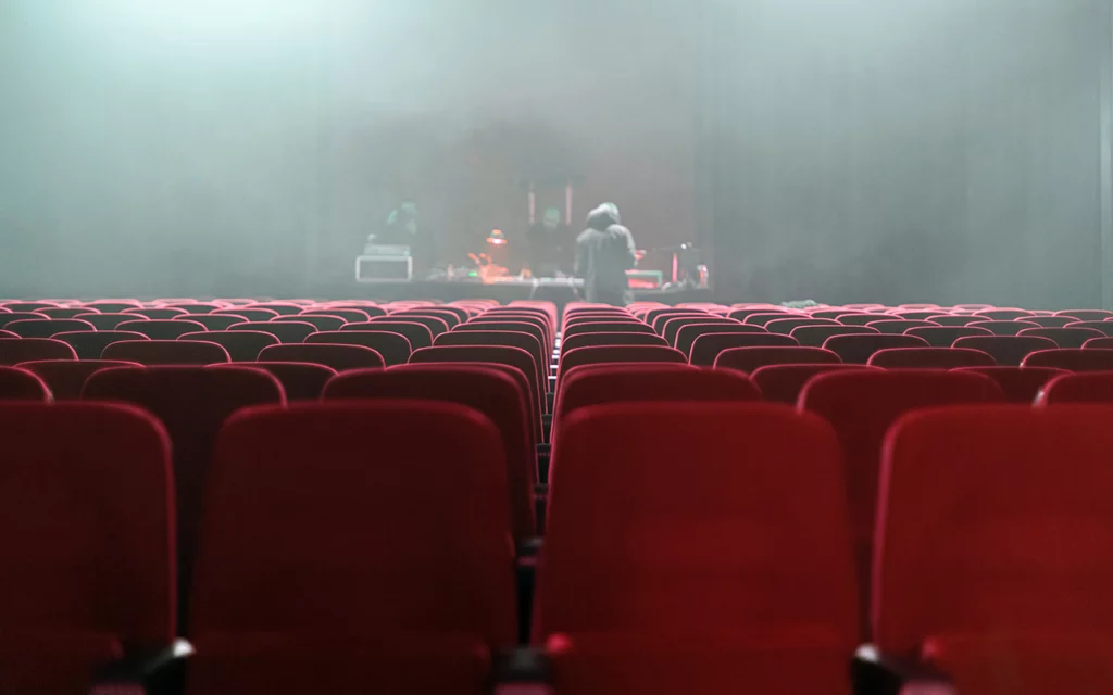 Rows of red seat at the Eccles Theater in Salt Lake City. Behind the seats is a sound booth area.