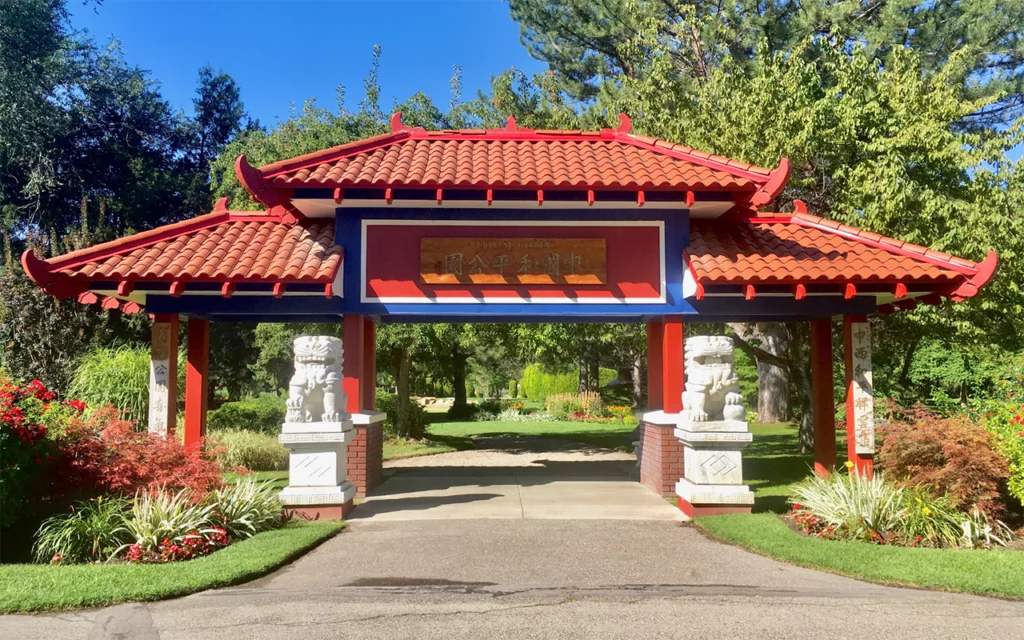 One of the entrances to the International Peace Gardens in Salt Lake City. The entrance has a paifang style, which is a traditional style of Chinese architectural arches or gateway sculptures. There are two stone dragons sitting outside of the entrance.