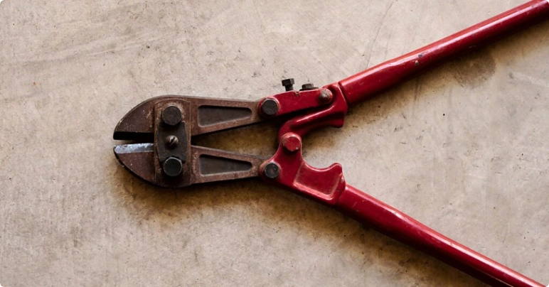 large pliers with red handles on concrete