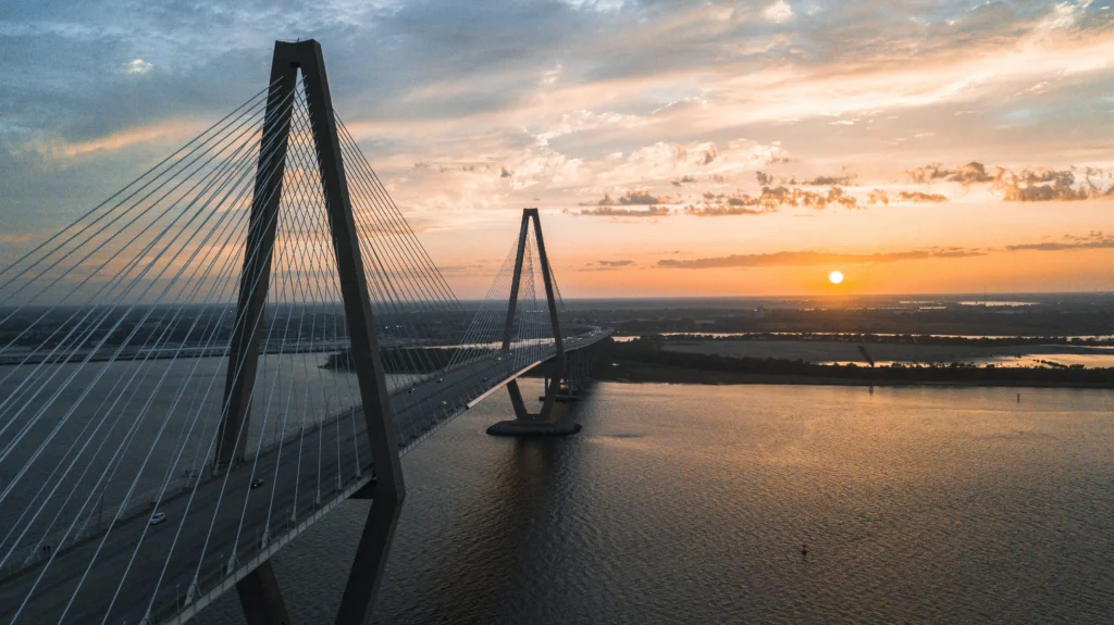 Image shows a bridge that is supported by towers and cables running over a body of water