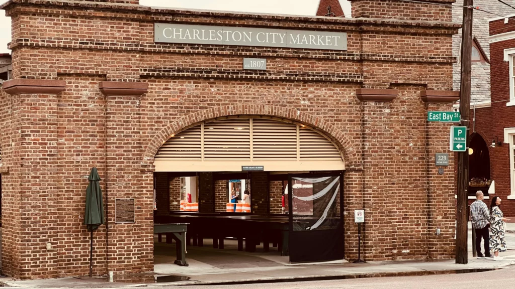 Brick building with a gateway bears a sign that says Charles City Market at the top