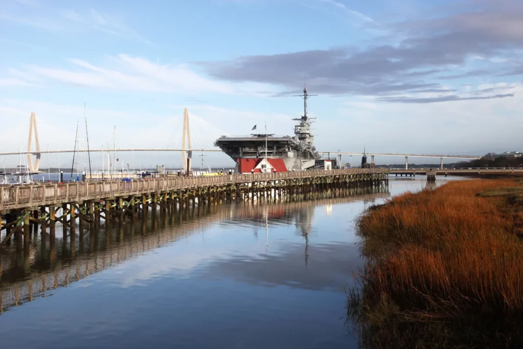 Image shows dock on a shoreline leading up to a building